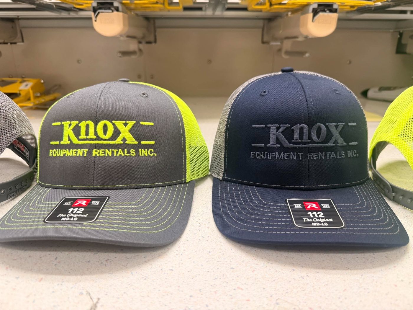 Gray and navy embroidered Knox Equipment Rentals hats